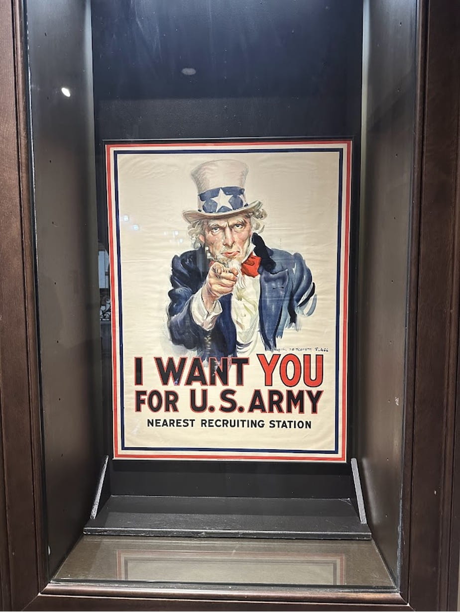 An Uncle Sam recruiting poster in a glass case.