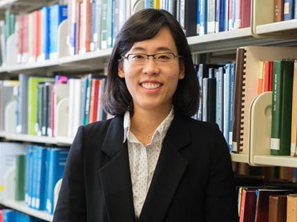 Haemin Kim smiles in the Hagerty Library stacks.