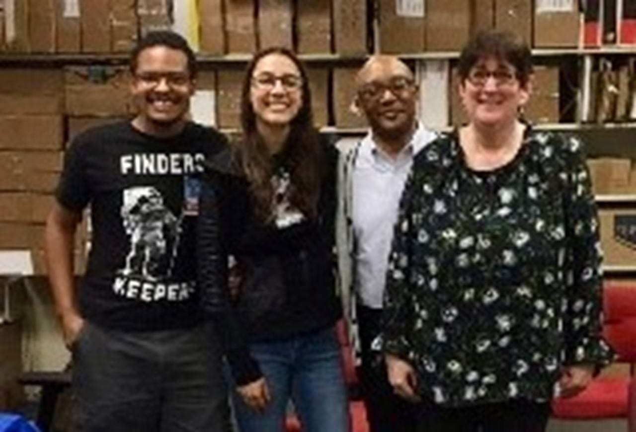 Two men and two women stand side-by-side and pose for a photo in the W. W. Hagerty Library