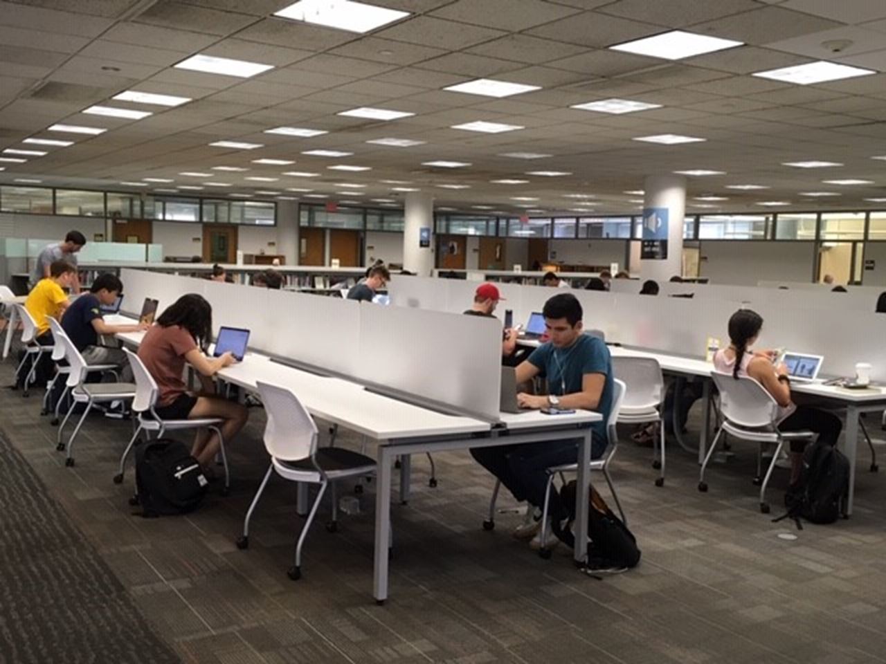 Students sit at new tables with privacy screens in the Hagerty Library