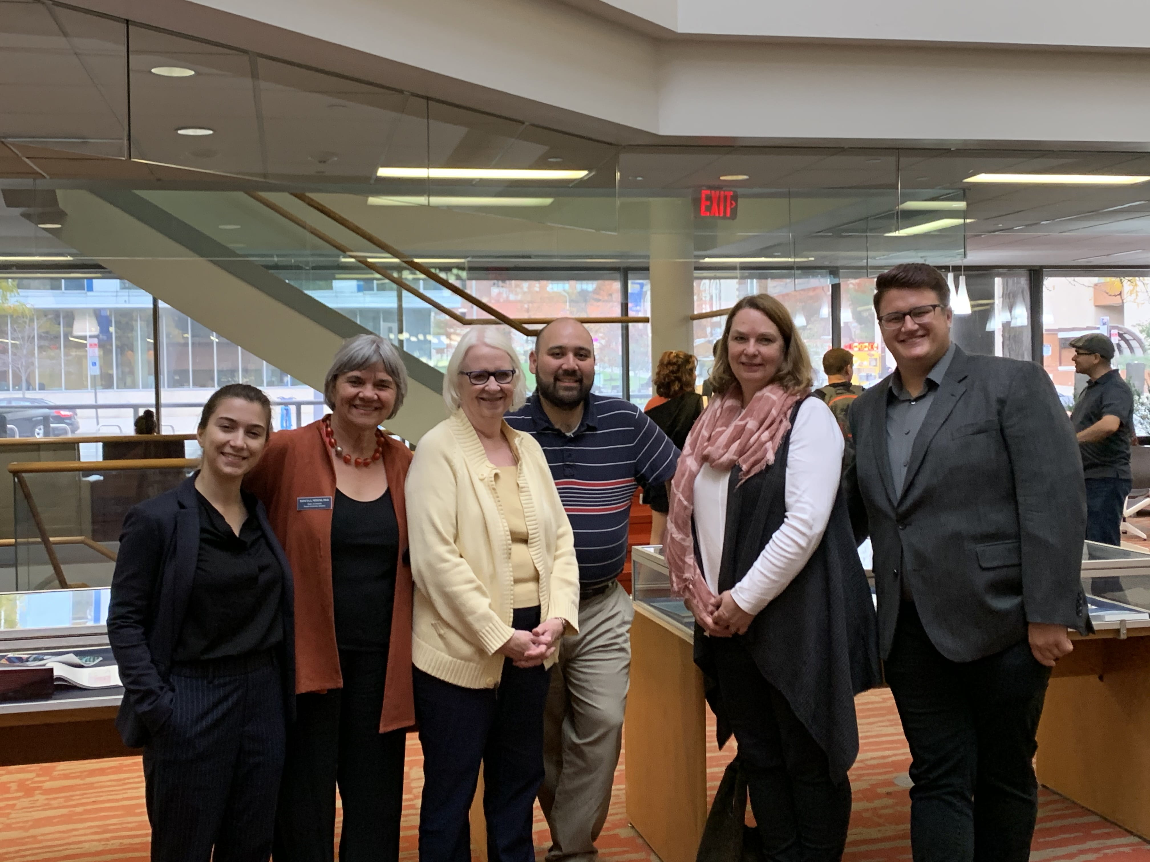 Four women and two men stand shoulder to shoulder in the lobby of the W. W. Hagerty Library 