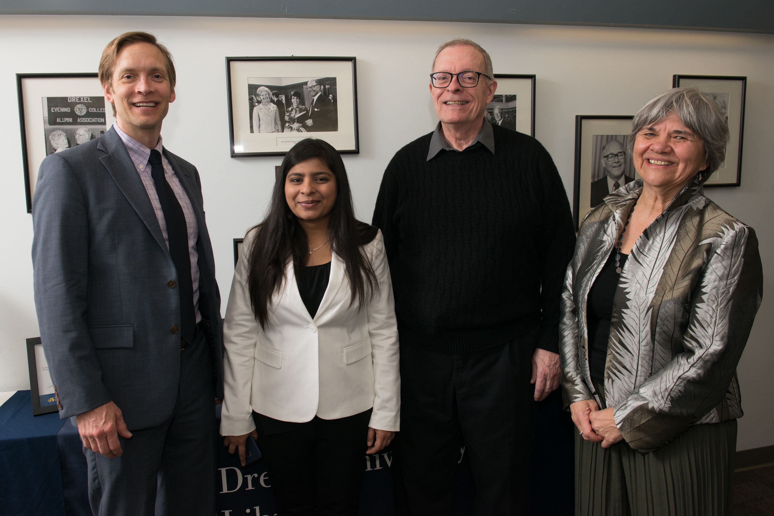 Two men and two women stand side-by-side and smile for the camera. 