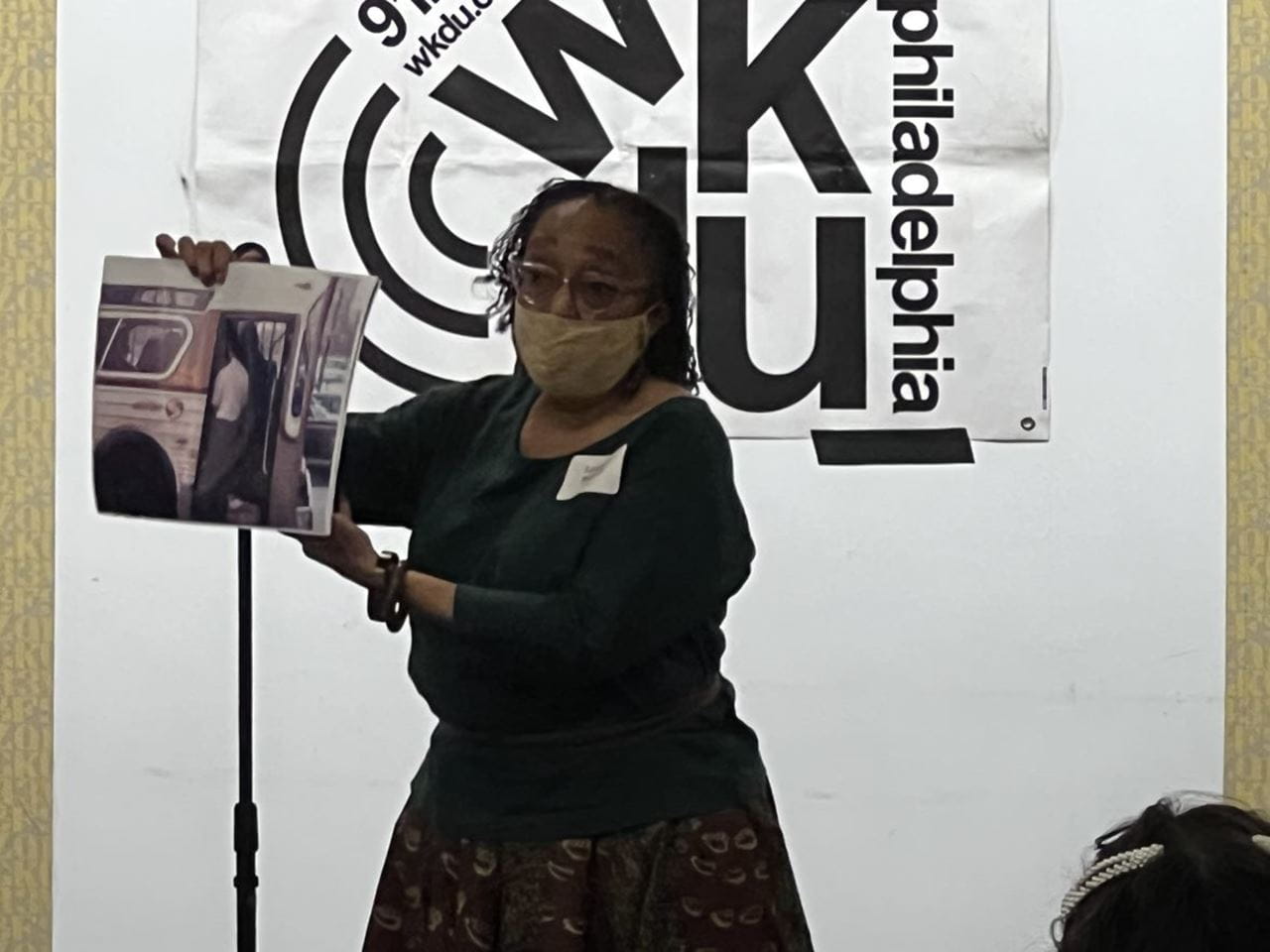 Laverne Battiste holds up a photo during the WKDU Exhibit Opening Event