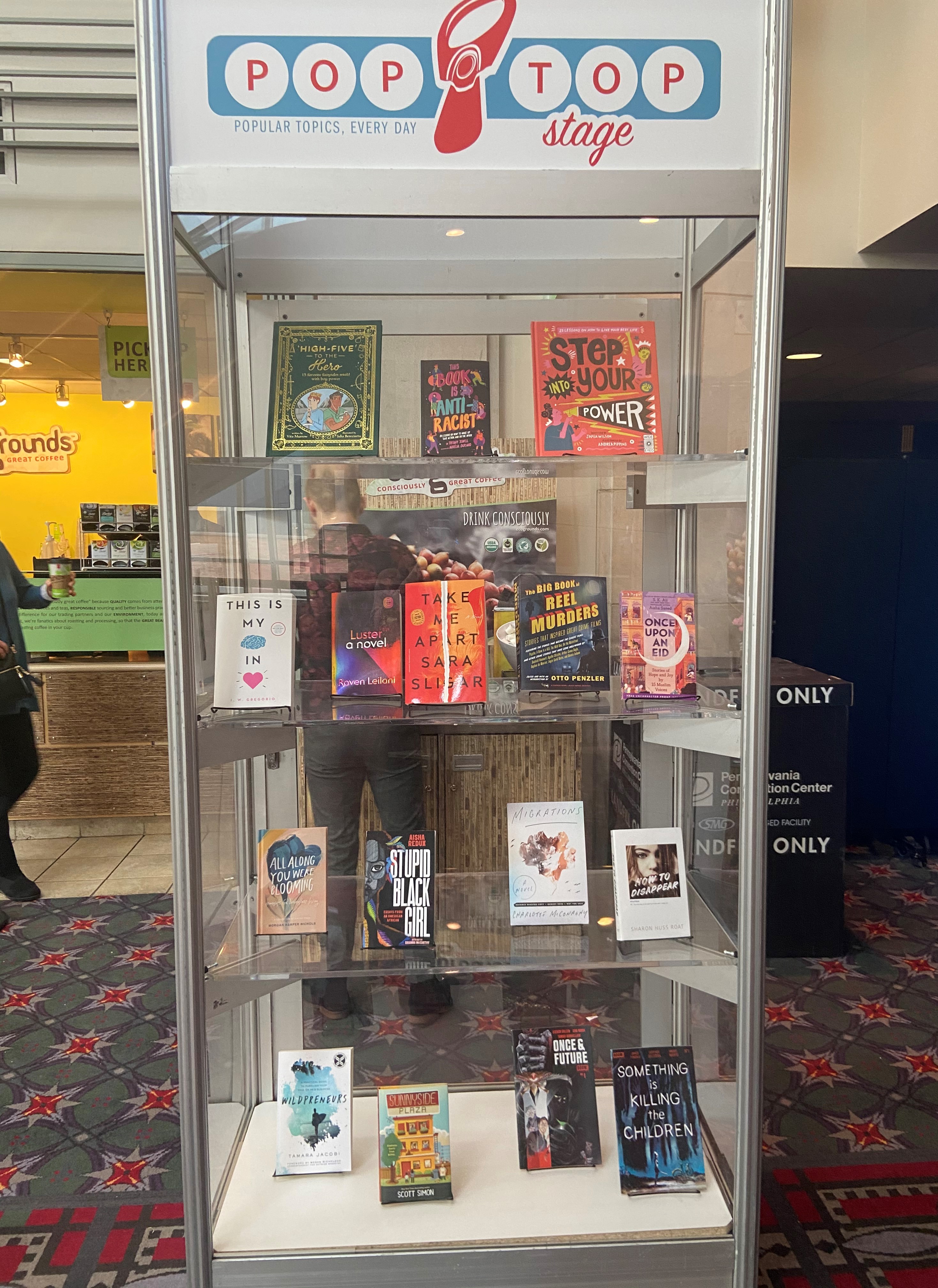 A display case with books on each shelf